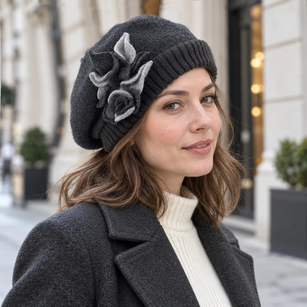 Woman wearing the charcoal gray floral beret with a dark coat on a city street