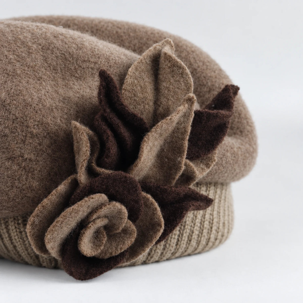 Close-up of the layered flower and leaf detail on the taupe beret
