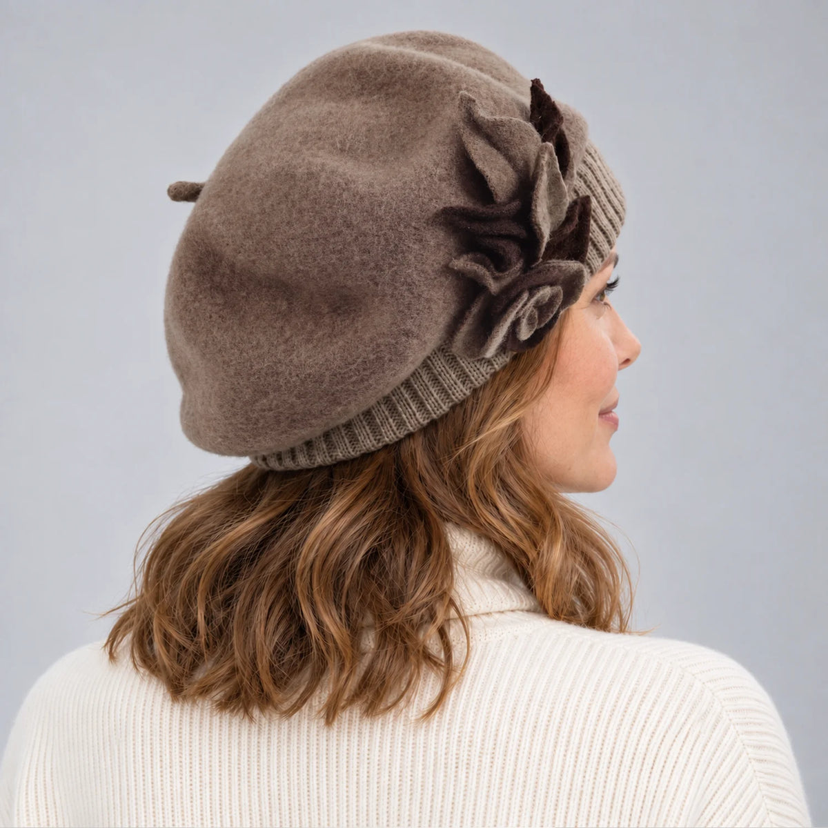 Side profile of a woman wearing the taupe floral beret with an ivory sweater