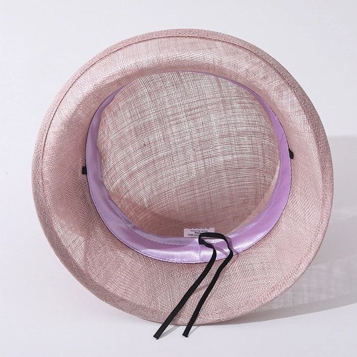 Inside view of a pink cloche sinamay hat showing the satin lining and adjustable band for a perfect fit.