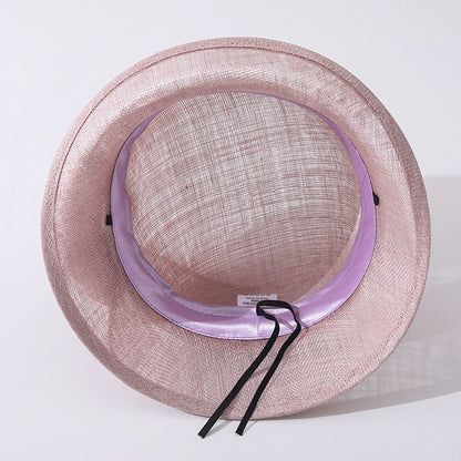 Inside view of a pink cloche sinamay hat showing the satin lining and adjustable band for a perfect fit.