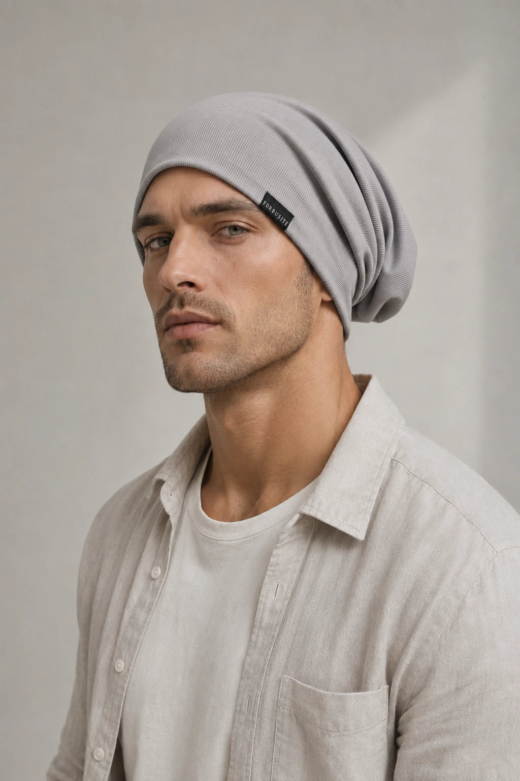 Man wearing a light gray lightweight slouchy beanie with soft folds behind the head