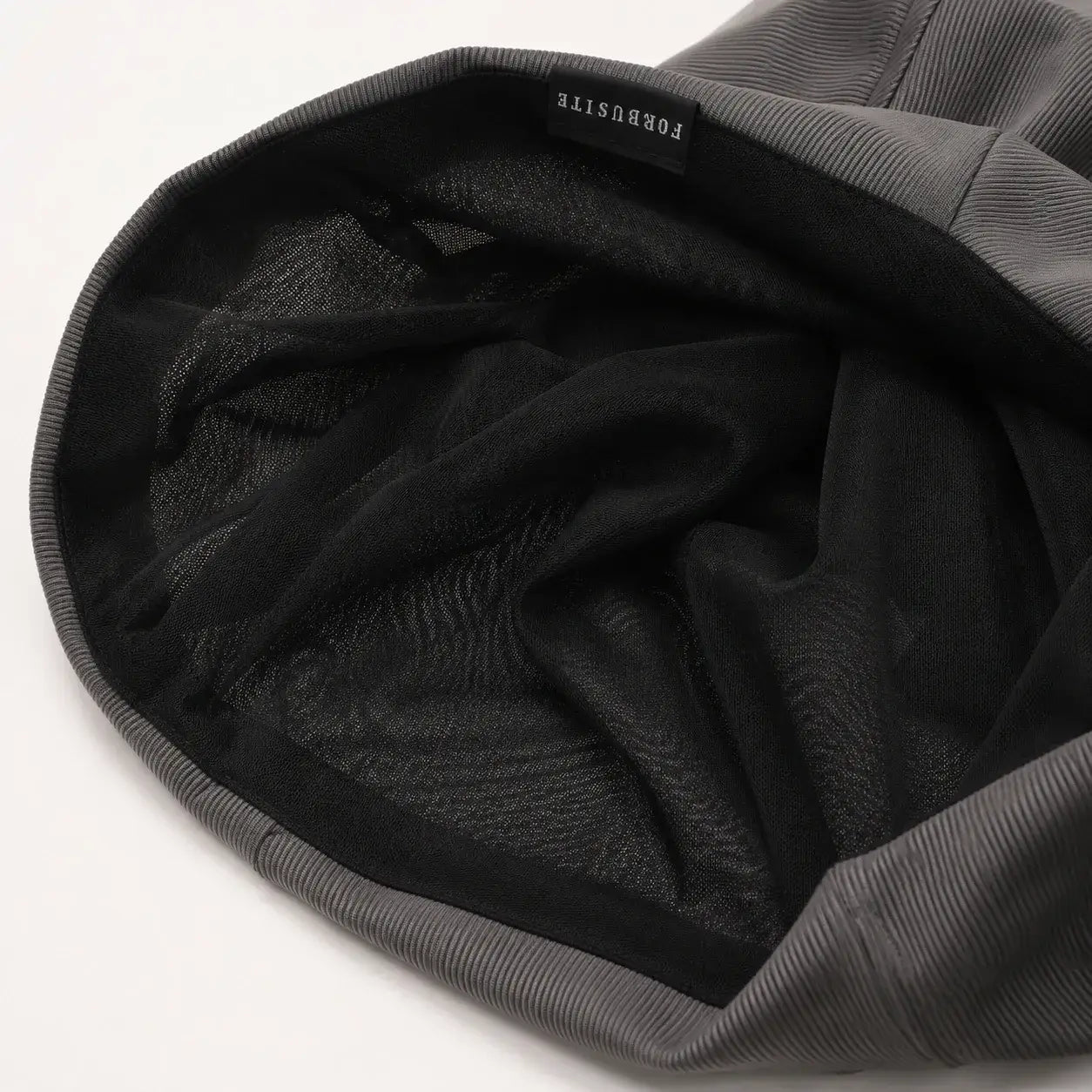 Inside view of a lightweight slouchy beanie showing the inner lining and finished edge