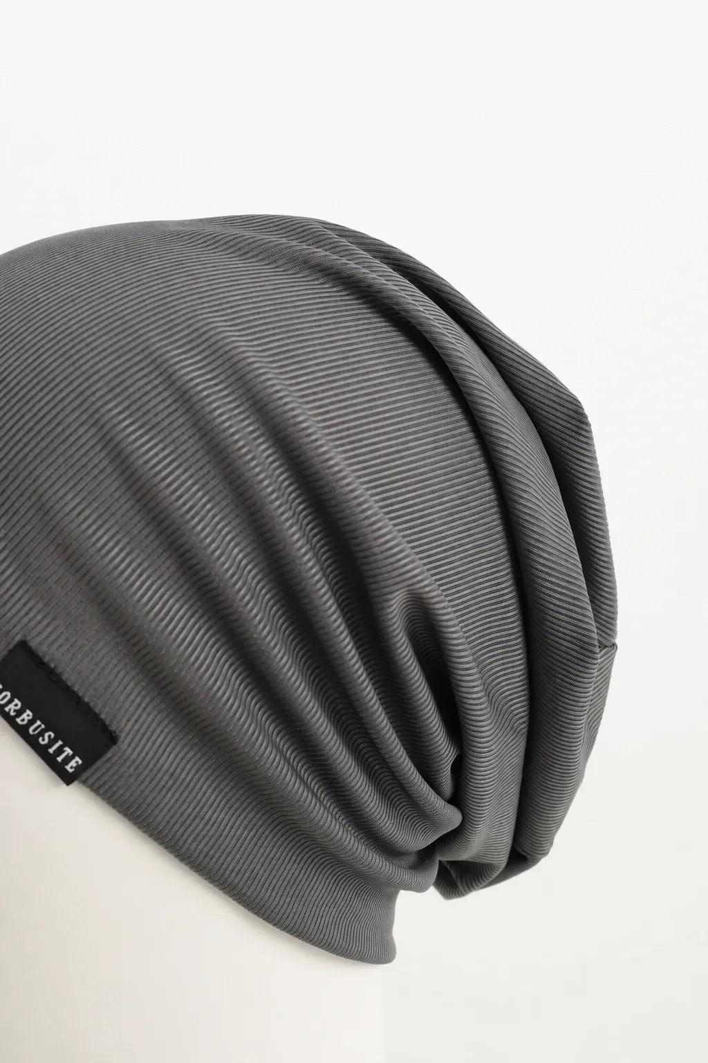 Close-up of the soft fine ribbed fabric and natural folds on a lightweight slouchy beanie