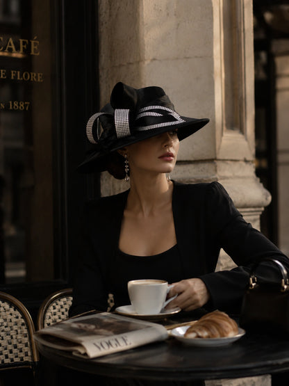 Elegant woman wearing luxury black church hat with rhinestone details in upscale cafe setting