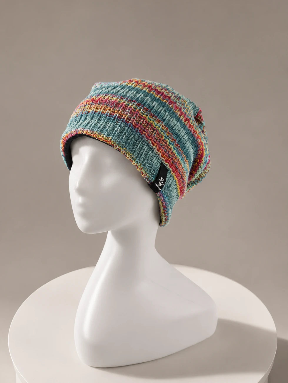 Luxury colorful knit slouchy beanie displayed on minimalist mannequin