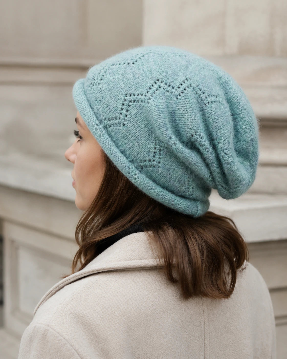 Woman wearing a mint green slouchy beanie with a winter coat