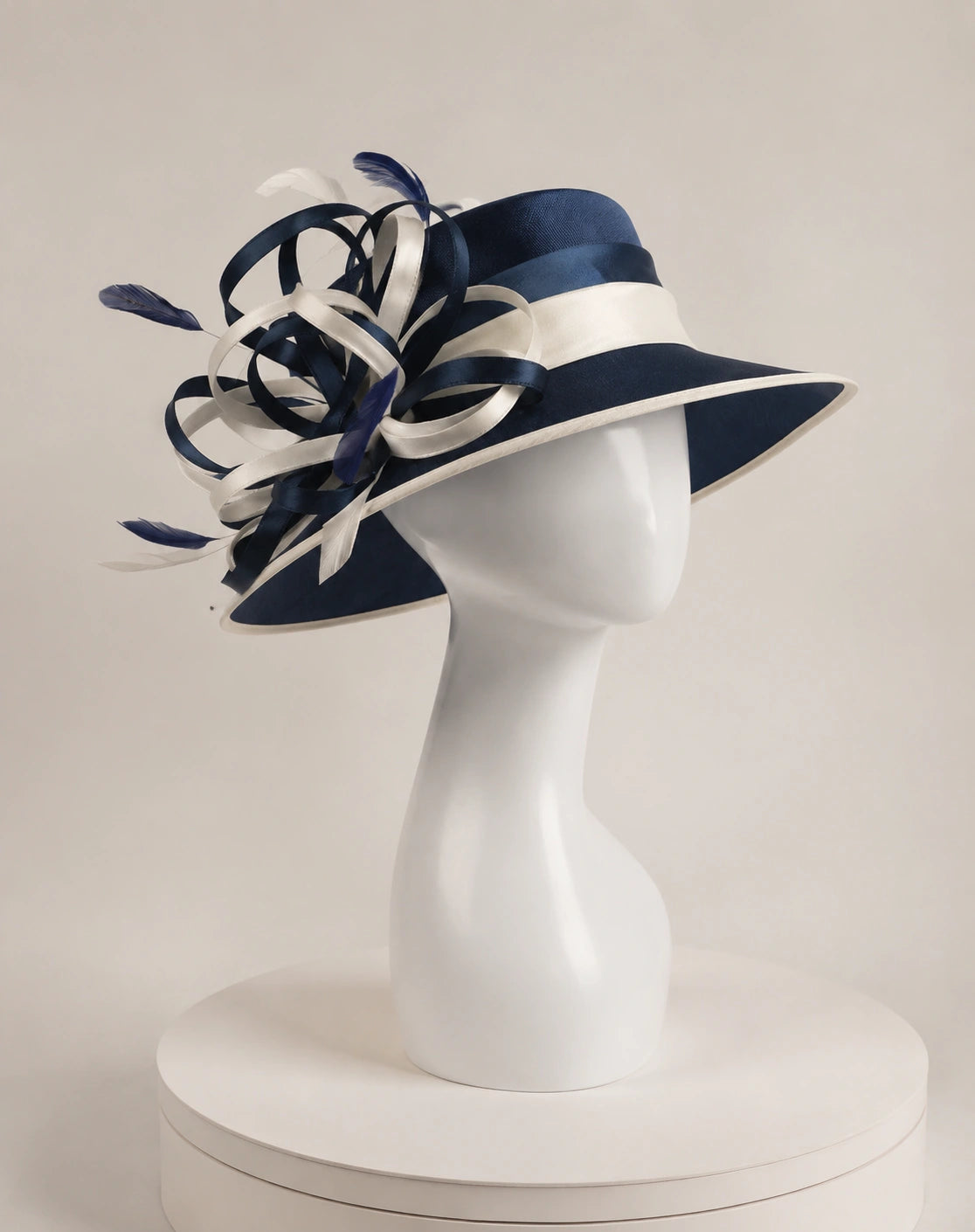 Side view of navy blue church hat on mannequin with white satin trim and decorative ribbon loops, formal women’s hat for church events