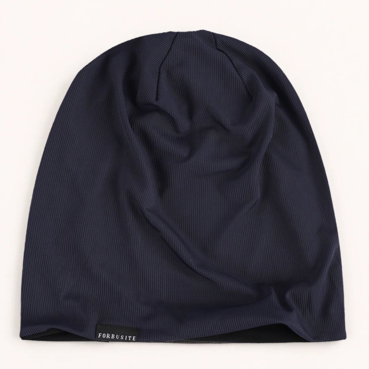 Navy blue lightweight slouchy beanie with smooth ribbed fabric and relaxed uncuffed shape