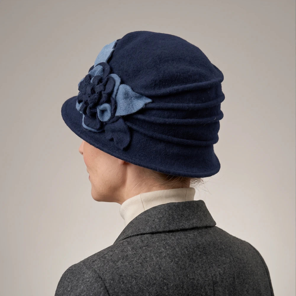 Rear side view of a navy ruched wool cloche hat worn by a woman