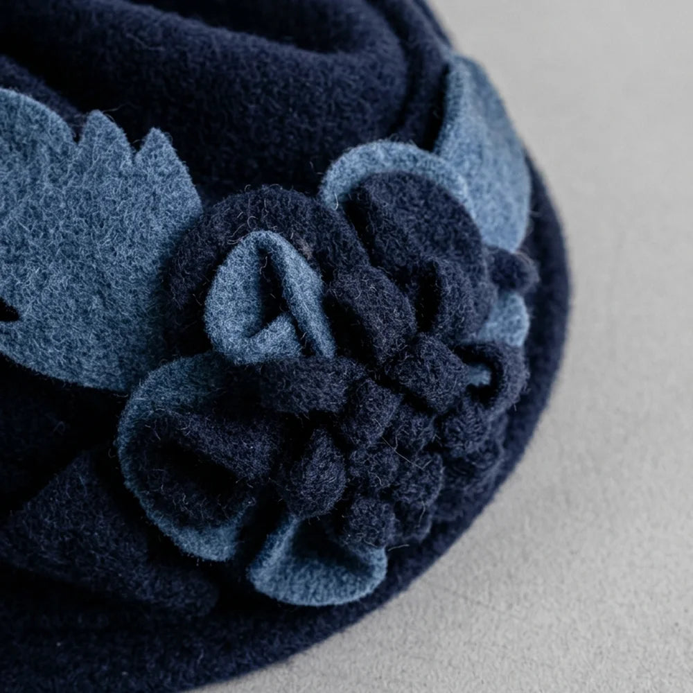 Close-up of the fixed flowers and leaves on a navy wool cloche hat