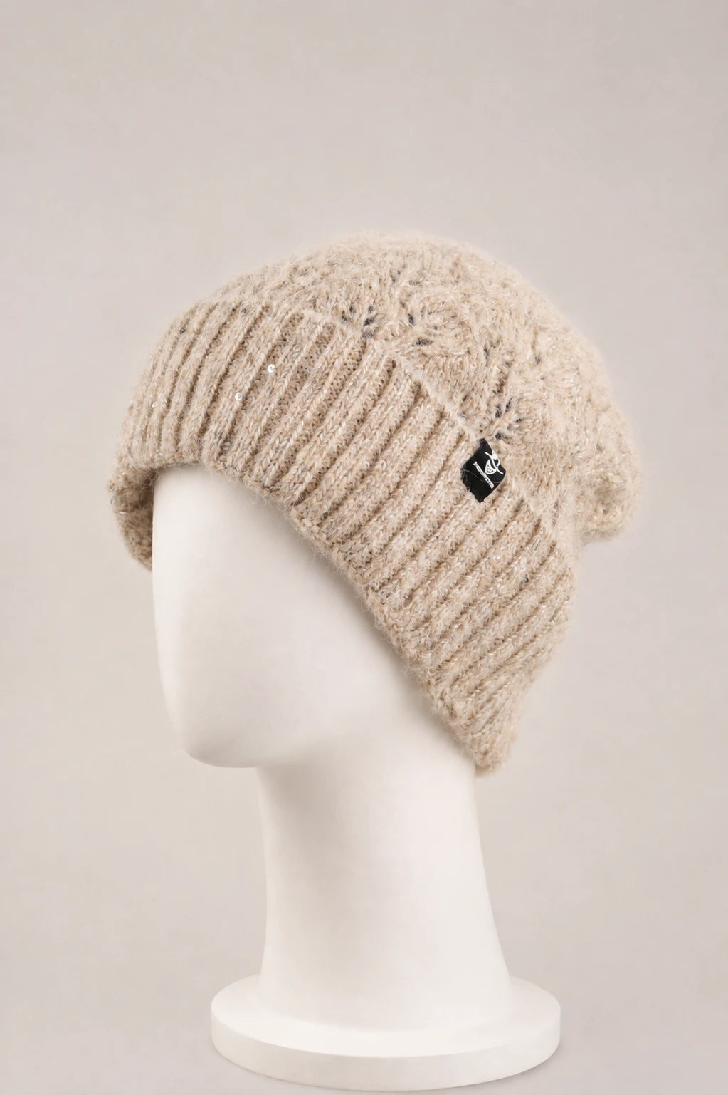 oatmeal fuzzy sequin cuffed beanie displayed on a matte white mannequin.