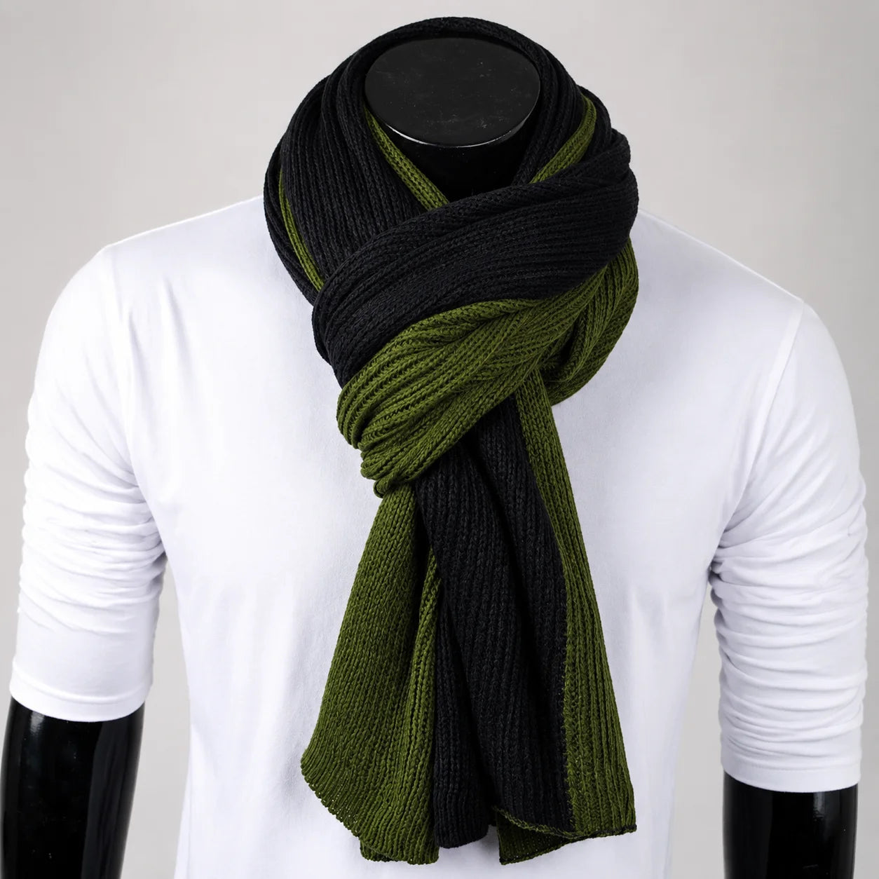 Olive green and black melange knit scarf on mannequin, ribbed winter texture inspired by military urban fashion