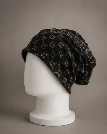 Side profile view of oversized black beanie hat featuring soft knit construction, baggy slouch design and jacquard double C pattern.