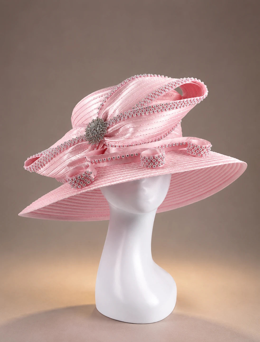 Pink wide brim formal hat on mannequin featuring crystal embellishments and sophisticated women’s church fashion style