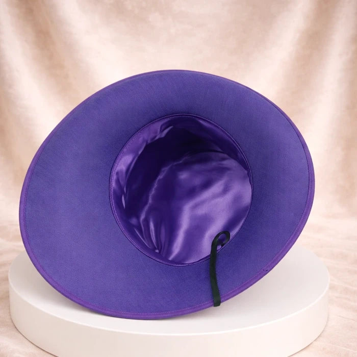 Purple formal hat with feather details, ideal for wedding guests and church celebrations.