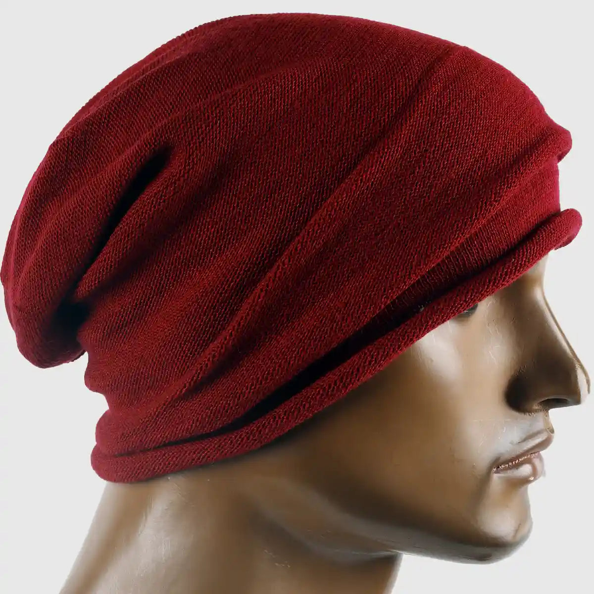Red slouchy beanie hat for men and women, made from soft cotton knit. Perfect for winter wear. Casual, stylish design with a relaxed fit for year-round comfort. Available in multiple colors.