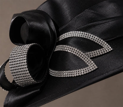 Close up detail of rhinestone embellishment and satin texture on luxury black church hat