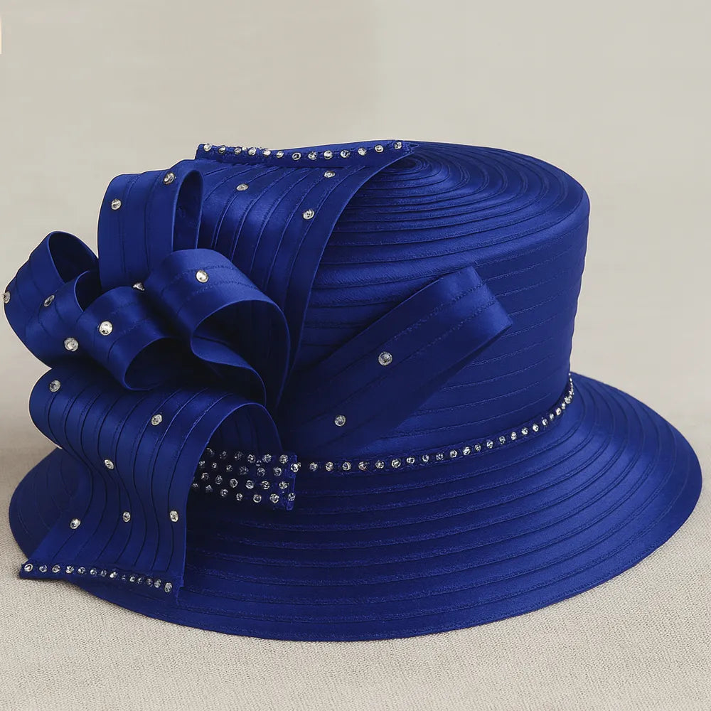 Elegant royal blue church hat with rhinestone bow detail on white turntable, perfect for women’s Sunday service or tea party