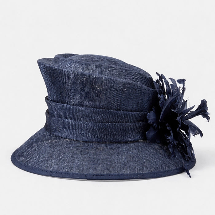 Side view of a luxurious navy sinamay hat with a beautiful feather arrangement, designed for high-end occasions.