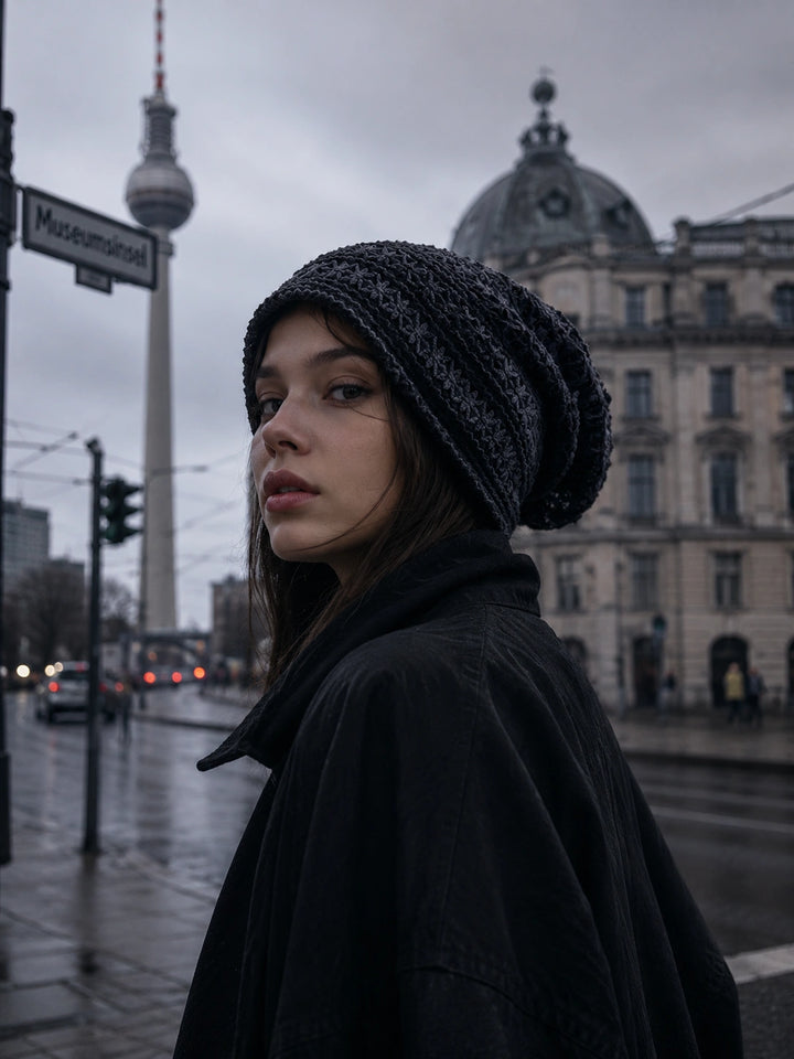 Urban street style woman wearing dark slouchy beanie in modern city fashion look