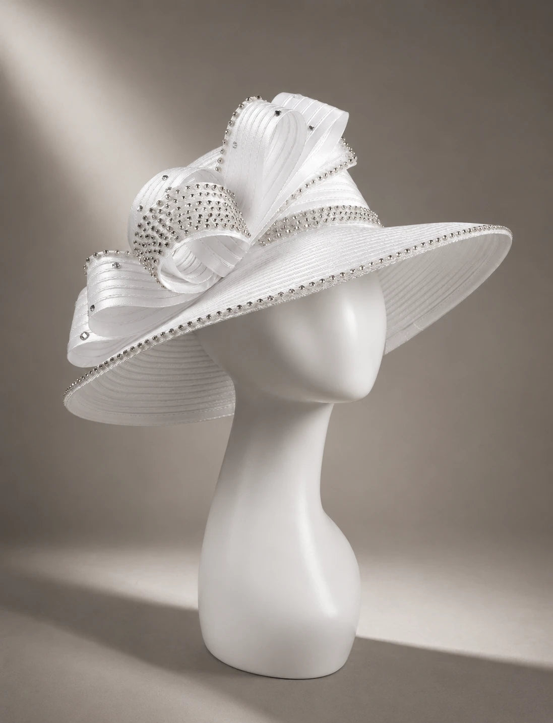 Side view of elegant white wide brim church hat with rhinestone trim and sculpted ribbon design