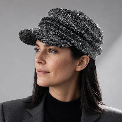 Woman wearing a black and silver ruched visor cap with satin lining and rhinestone detail