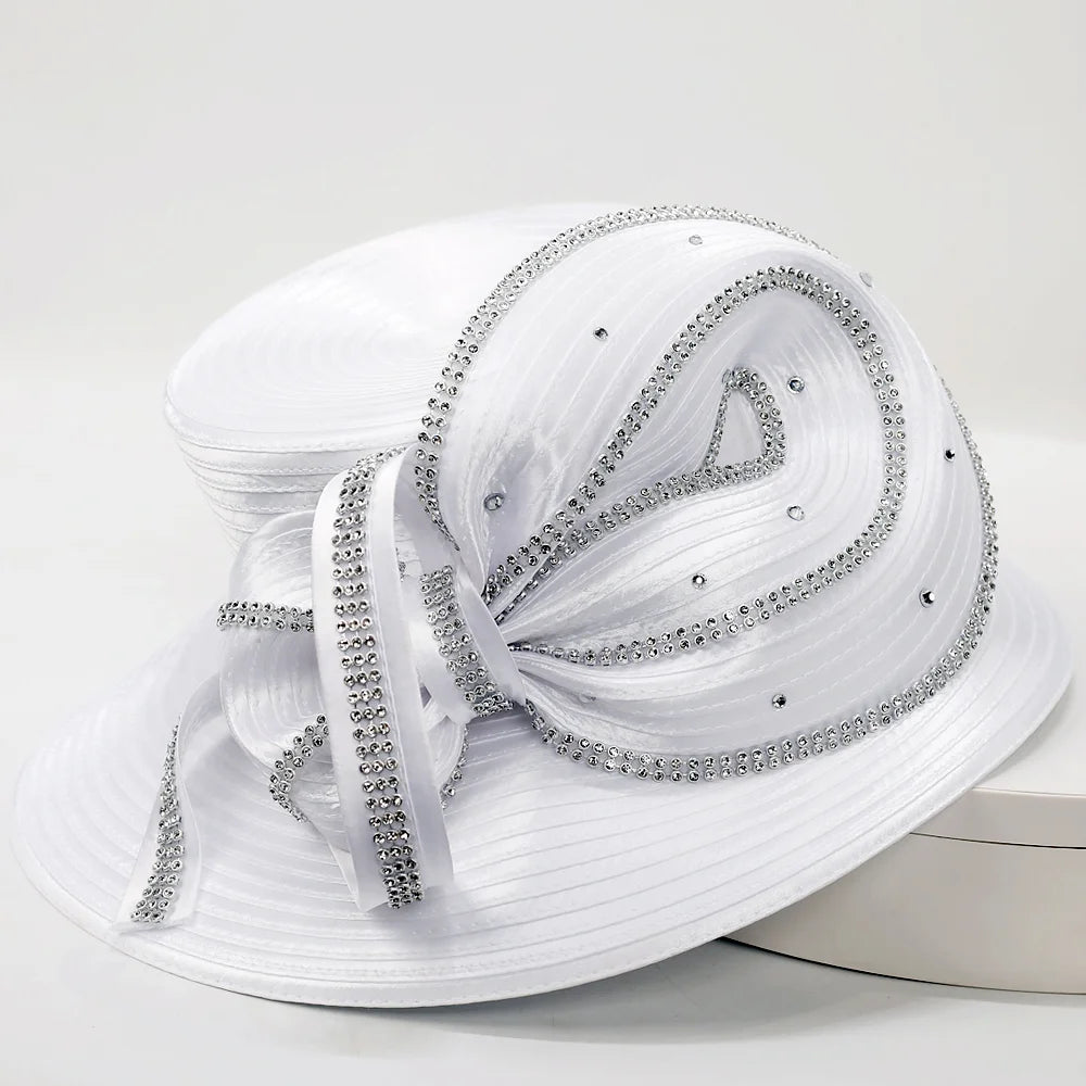 Side angle of a wide-brimmed white formal hat featuring a sculptural bow and crystal embellishments, perfect for high tea or formal events.